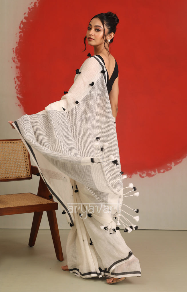 A striking White Linen Saree With woven in Pom Pots